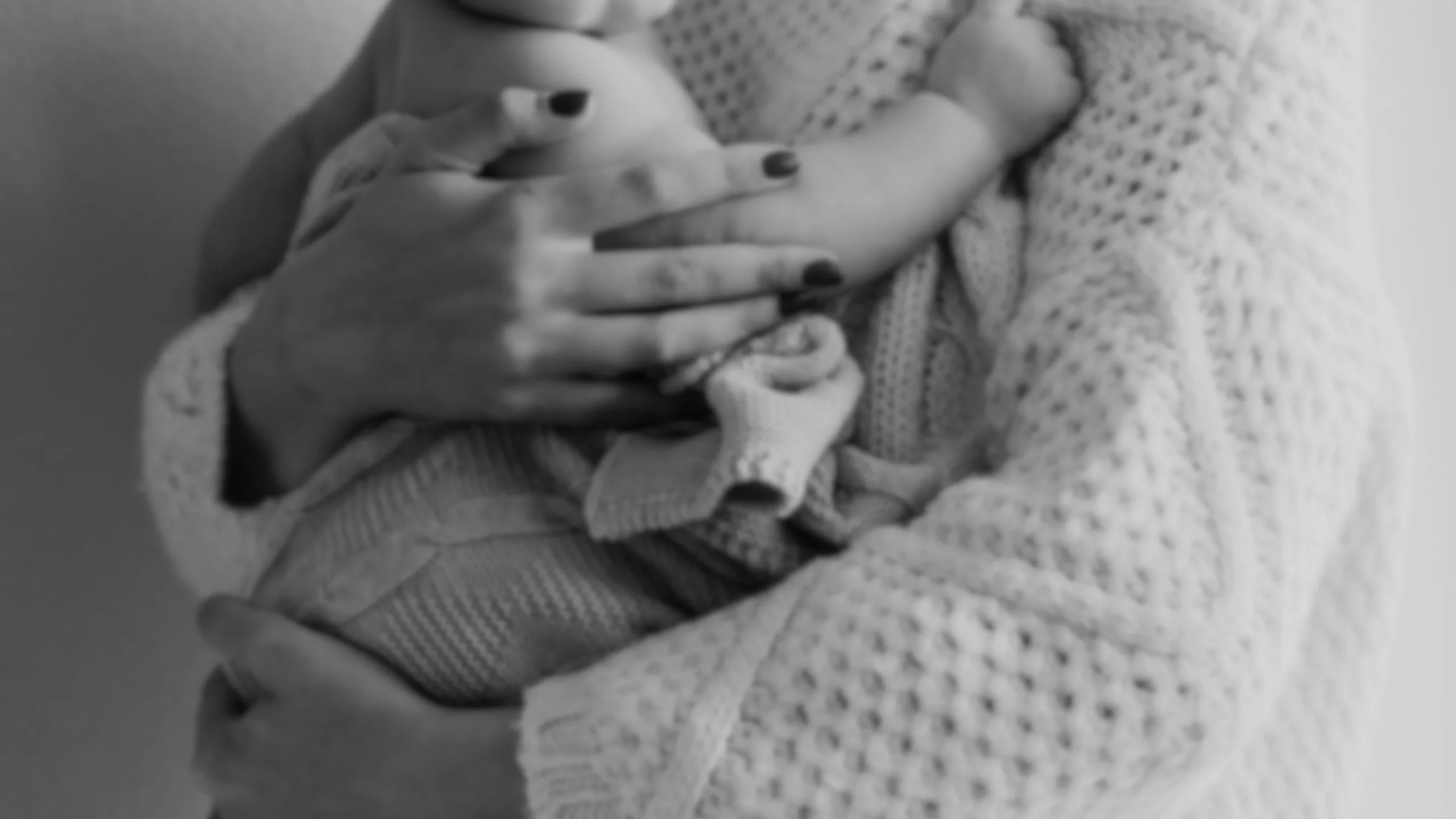 Photographie en noir et blanc d'un moment de douceur entre parent et enfant, accompagnement périnatalité et parentalité par Morgane Bessa à Limoges.